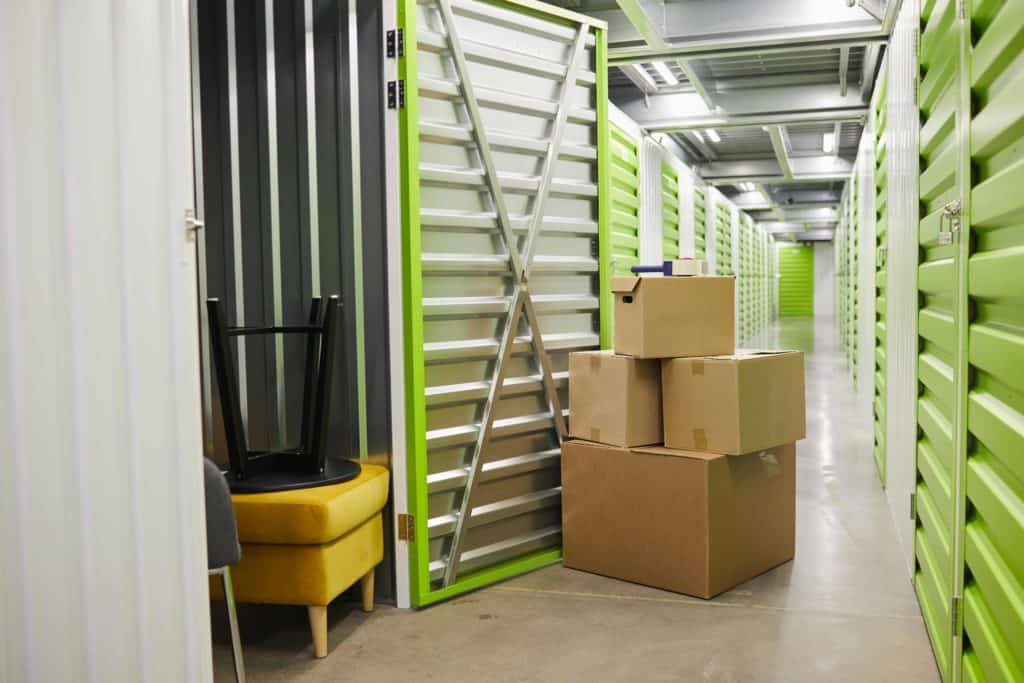 cardboard boxes stacked by open door of self storage unit